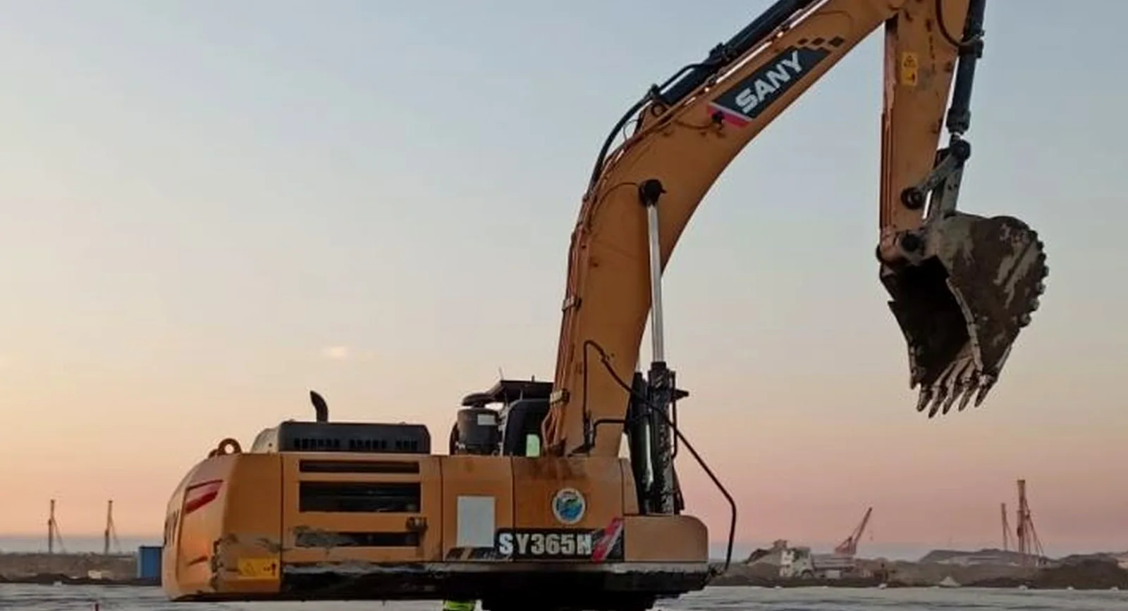 Kazi Reliance excavator on a civil works site at dusk
